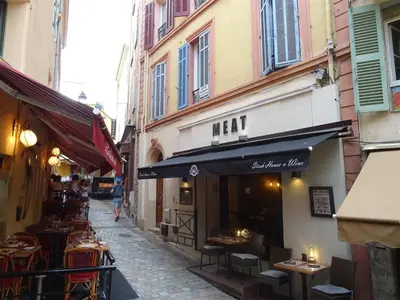a street with tables and chairs and a restaurant at Apartment Rue St Antoine in Cannes