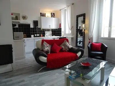 a living room with a red couch and a table at Apartment Rue St Antoine in Cannes