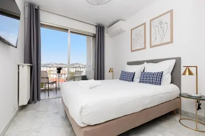 a bedroom with a large bed and a large window at Superbe appartement à Cannes vue mer panoramique 