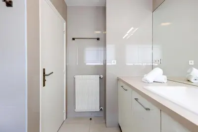 a white bathroom with a sink and a shower at Superbe appartement à Cannes vue mer panoramique 