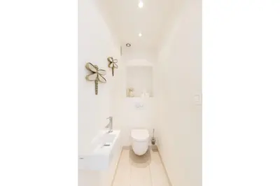 a white bathroom with a toilet and a sink at Superbe appartement à Cannes vue mer panoramique 