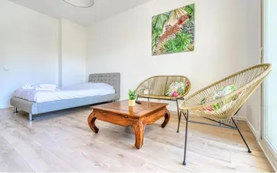 a room with a bed and two chairs and a table at Le Capri - Studio Wifi Californie in Cannes