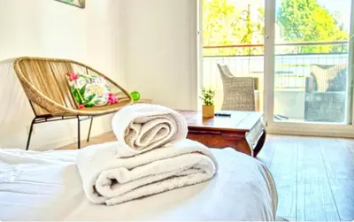 a pile of towels sitting on top of a bed at Le Capri - Studio Wifi Californie in Cannes