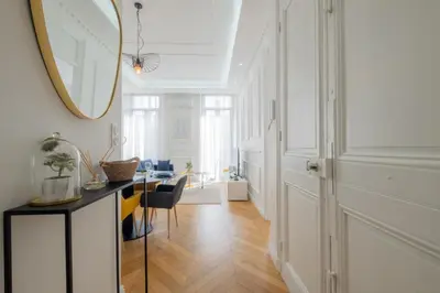 a living room with a table and a mirror at 3-Br Apartment in the heart of downtown in Cannes