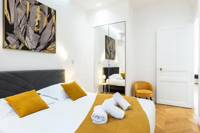 a bedroom with a large white bed with yellow pillows at 3-Br Apartment in the heart of downtown in Cannes