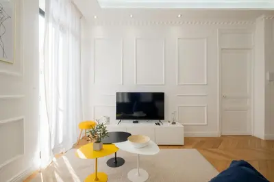 a living room with a tv and a table at 3-Br Apartment in the heart of downtown in Cannes