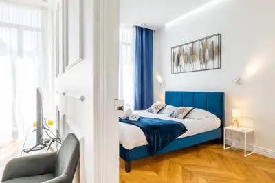 a bedroom with a blue bed and a chair at 3-Br Apartment in the heart of downtown in Cannes