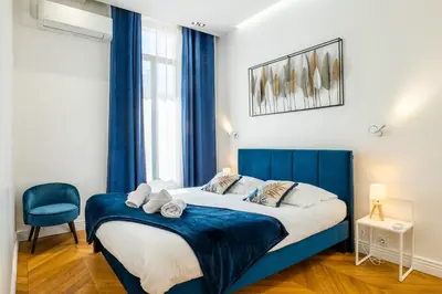 a bedroom with a blue bed and a blue chair at 3-Br Apartment in the heart of downtown in Cannes