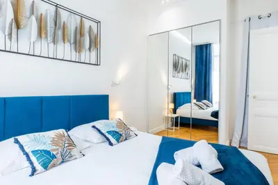 a bedroom with a large bed and a mirror at 3-Br Apartment in the heart of downtown in Cannes
