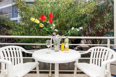 a white table with two chairs and a vase of flowers at MIPIM Dispo Perle Rare Croisette A côté de l Hôtel Carlton Centre Croisette 5mn du Palais 4P Plage 1Mn in Cannes