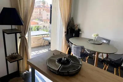 a living room with a table and a balcony at Cosy 42m With Balcony Nice View And Wifi in Cannes