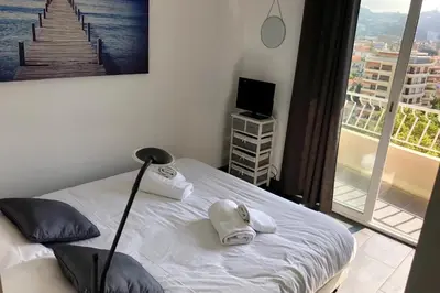 a bedroom with a bed and a view of a city at Cosy 42m With Balcony Nice View And Wifi in Cannes
