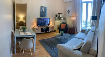 a living room with a couch and a table and a tv at 2 pièces cannes centre in Cannes