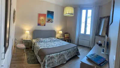 a bedroom with a bed and a table and a window at 2 pièces cannes centre in Cannes