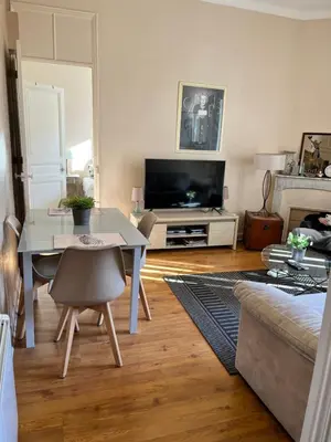 a living room with a table and a tv at 2 pièces cannes centre in Cannes