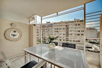 a dining room with a table and a large window at Agréable 2 pièces TERRASSE, PISCINE, Clémenceau A1B235 in Cannes