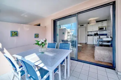 a dining room with a table and blue chairs at Agréable 2 pièces TERRASSE, PISCINE, Clémenceau A1B235 in Cannes