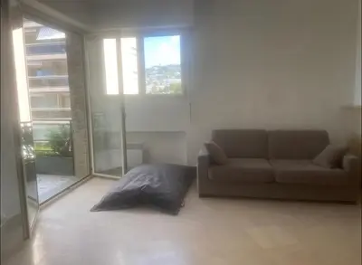 a living room with a couch and some windows at palm Beach studio vue port Canto in Cannes