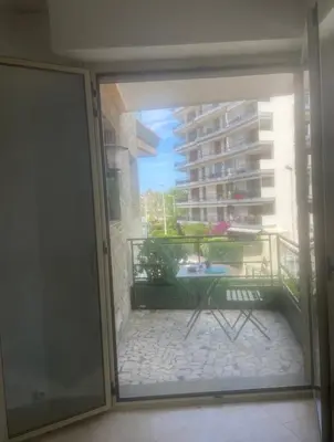 a sliding glass door leading to a balcony with a table at palm Beach studio vue port Canto in Cannes