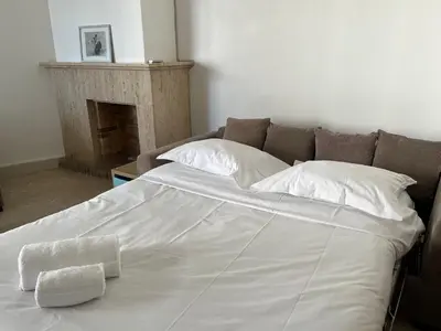 a large bed with white sheets and pillows on it at palm Beach studio vue port Canto in Cannes