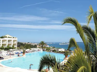 a large swimming pool with people in a resort at Apartment Villa Francia-1 by Interhome in Cannes