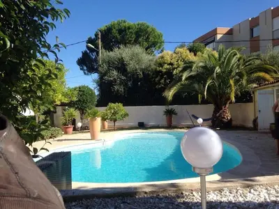 a swimming pool with a white ball next to a building at Villa élégante avec piscine privée à Le Cannet in Le Cannet
