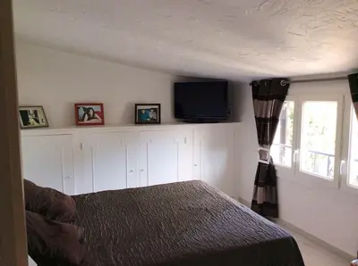 a bedroom with a bed and a flat screen tv at Villa élégante avec piscine privée à Le Cannet in Le Cannet