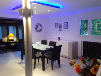 a dining room and living room with a table and chairs at Villa élégante avec piscine privée à Le Cannet in Le Cannet