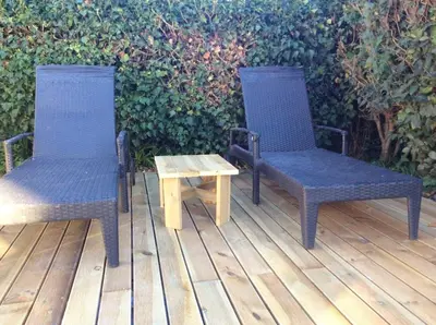 two chairs and a table on a wooden deck at Villa élégante avec piscine privée à Le Cannet in Le Cannet