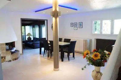 a dining room and living room with a table and chairs at Villa élégante avec piscine privée à Le Cannet in Le Cannet