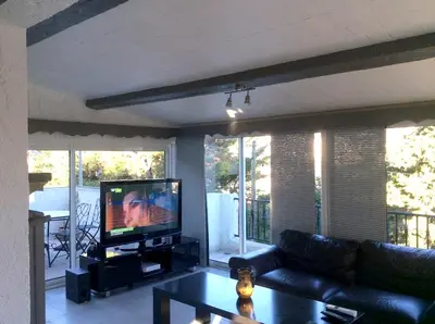 a living room with a couch and a television at Villa élégante avec piscine privée à Le Cannet in Le Cannet