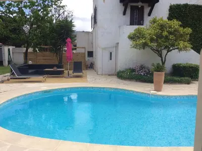 a large blue swimming pool in front of a house at Villa élégante avec piscine privée à Le Cannet in Le Cannet