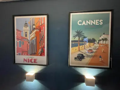 two posters are hanging on a wall with lights at CHEZ MATHIEU in Cannes