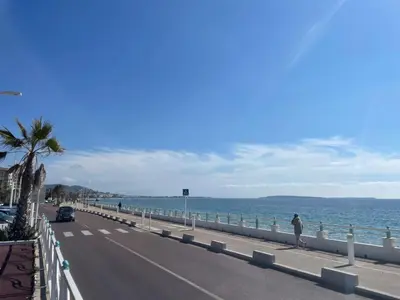 a man walking down a road next to the ocean at CHEZ MATHIEU in Cannes