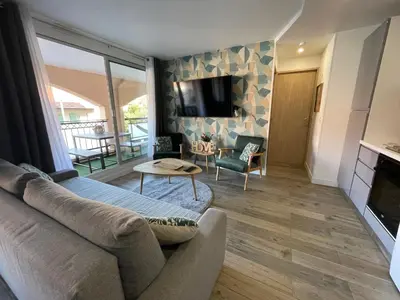 a living room with a couch and a tv and a table at CHEZ MATHIEU in Cannes