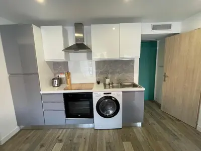 a kitchen with a washing machine and a sink at CHEZ MATHIEU in Cannes