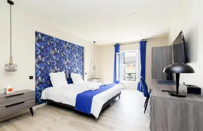 a bedroom with a large bed and a tv at 3 Bed - Ascenseur - 2 min du Palais - Climatisé in Cannes