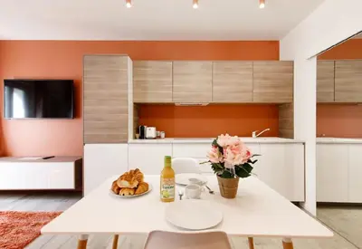 a kitchen with a white table with a vase of flowers at Studio O - ascenseur - 2 min du Palais - Climatisé in Cannes