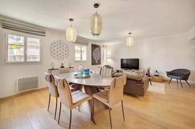 a living room with a table and a couch at Cannes banane 50m croisette, luxueux 4 pièces dans résidence de standing in Cannes