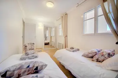 a bedroom with two beds and a window at Cannes banane 50m croisette, luxueux 4 pièces dans résidence de standing in Cannes
