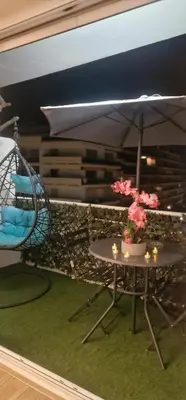 a room with a table and an umbrella and a swing at Appart 1 pièce pointe de la Croisette à cannes in Cannes
