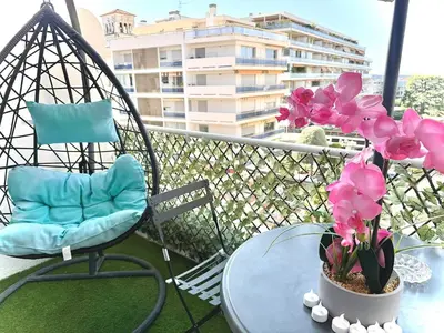 a table and chairs on a balcony with flowers at Appart 1 pièce pointe de la Croisette à cannes in Cannes