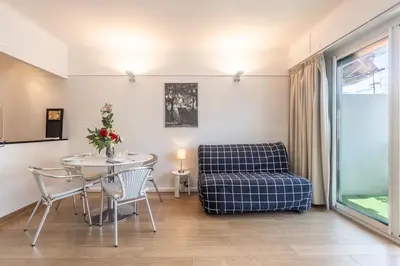 a living room with a table and a chair at Appart 1 pièce pointe de la Croisette à cannes in Cannes
