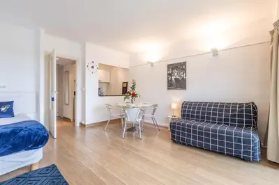 a bedroom with a bed and a table and a couch at Appart 1 pièce pointe de la Croisette à cannes in Cannes