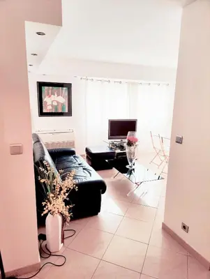a kitchen with black and white cabinets and two stools at One bedroom flat with terrace, 250m from the beach and La Croisette, Behind the Martinez Hotel in Cannes