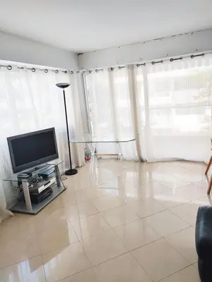 a kitchen with white cabinets and a vase of flowers at One bedroom flat with terrace, 250m from the beach and La Croisette, Behind the Martinez Hotel in Cannes