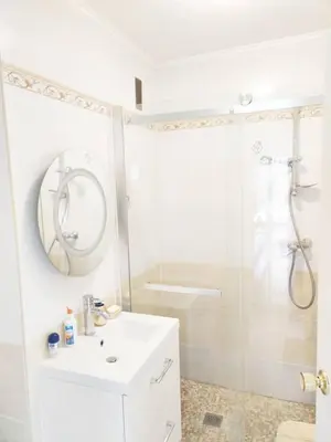 a black leather couch and a stool in a living room at One bedroom flat with terrace, 250m from the beach and La Croisette, Behind the Martinez Hotel in Cannes