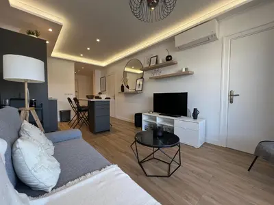 a living room with a couch and a television at Cosy 2 bedrooms apartment Croisette in Cannes