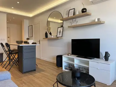 a living room with a tv and a table at Cosy 2 bedrooms apartment Croisette in Cannes
