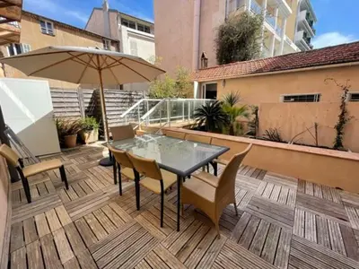 a patio with a table and chairs and an umbrella at La Fontaine in Cannes